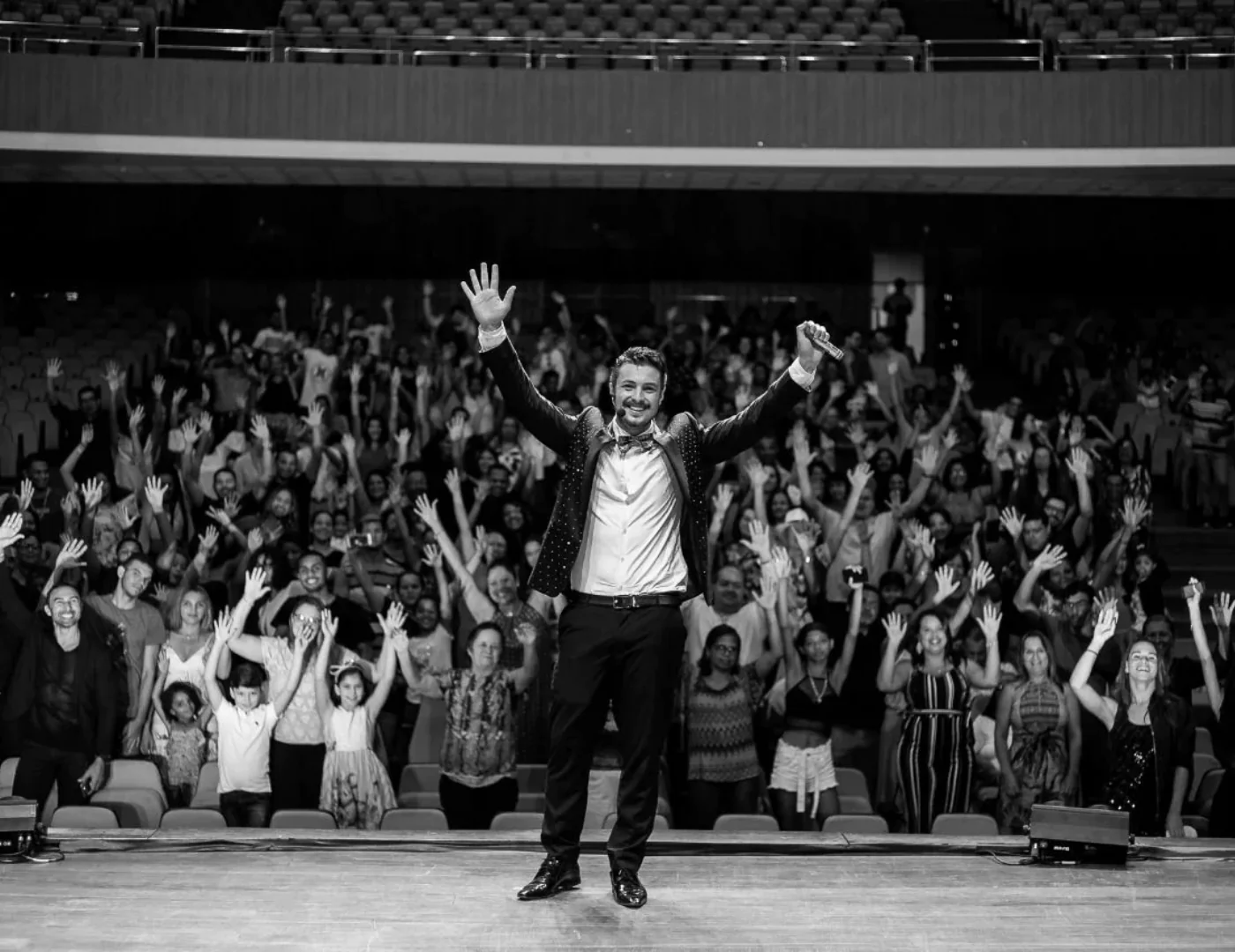 Rafael Mozzato em evento ao vivo, com o público de braços erguidos